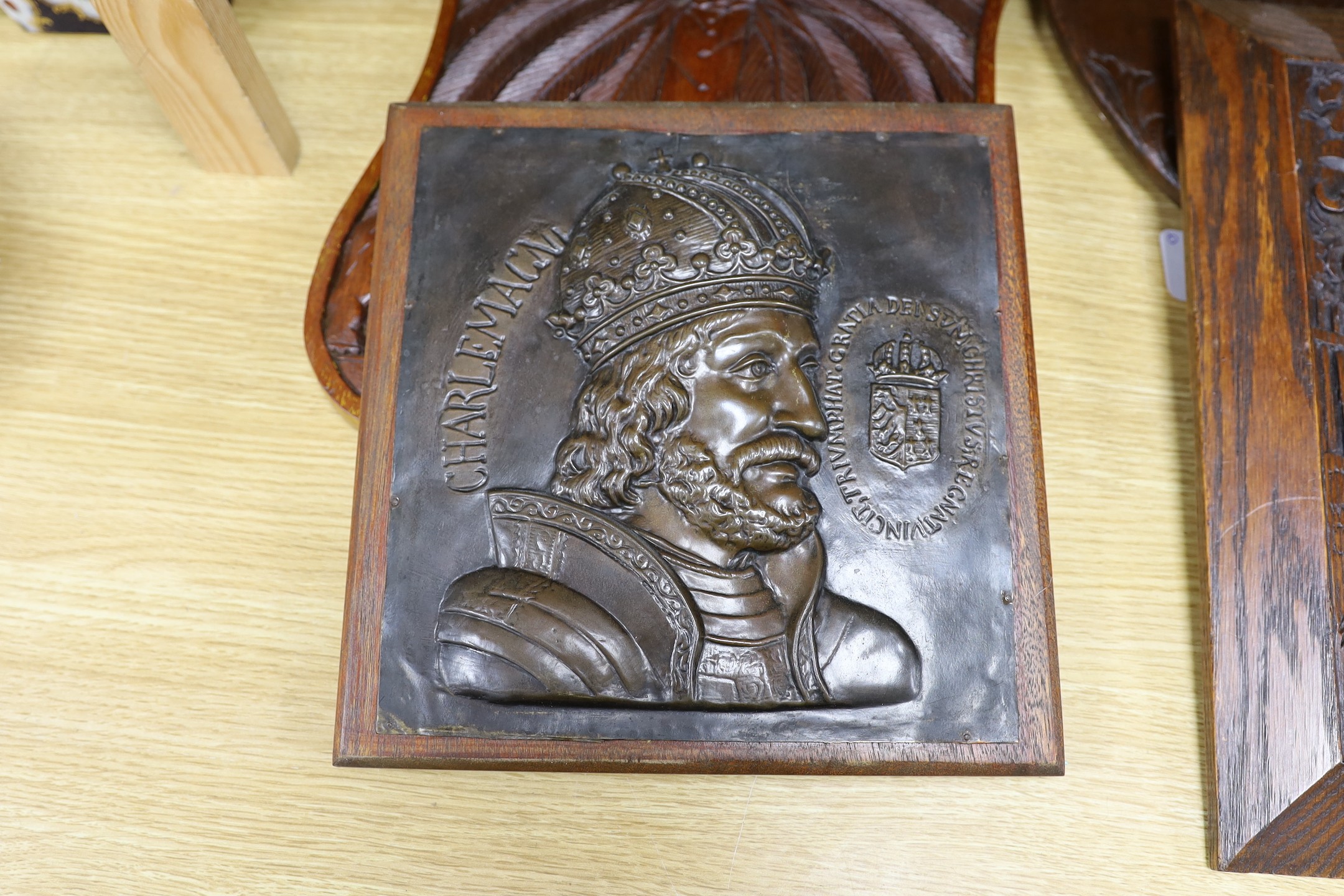 Six mixed oak carved panels and a metal relief mounted panel
